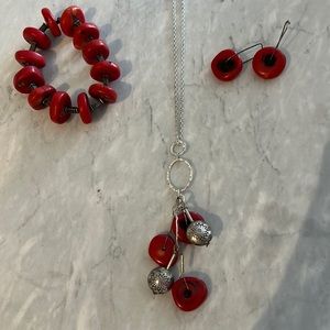 Matching red necklace, bracelet and pierced earrings.